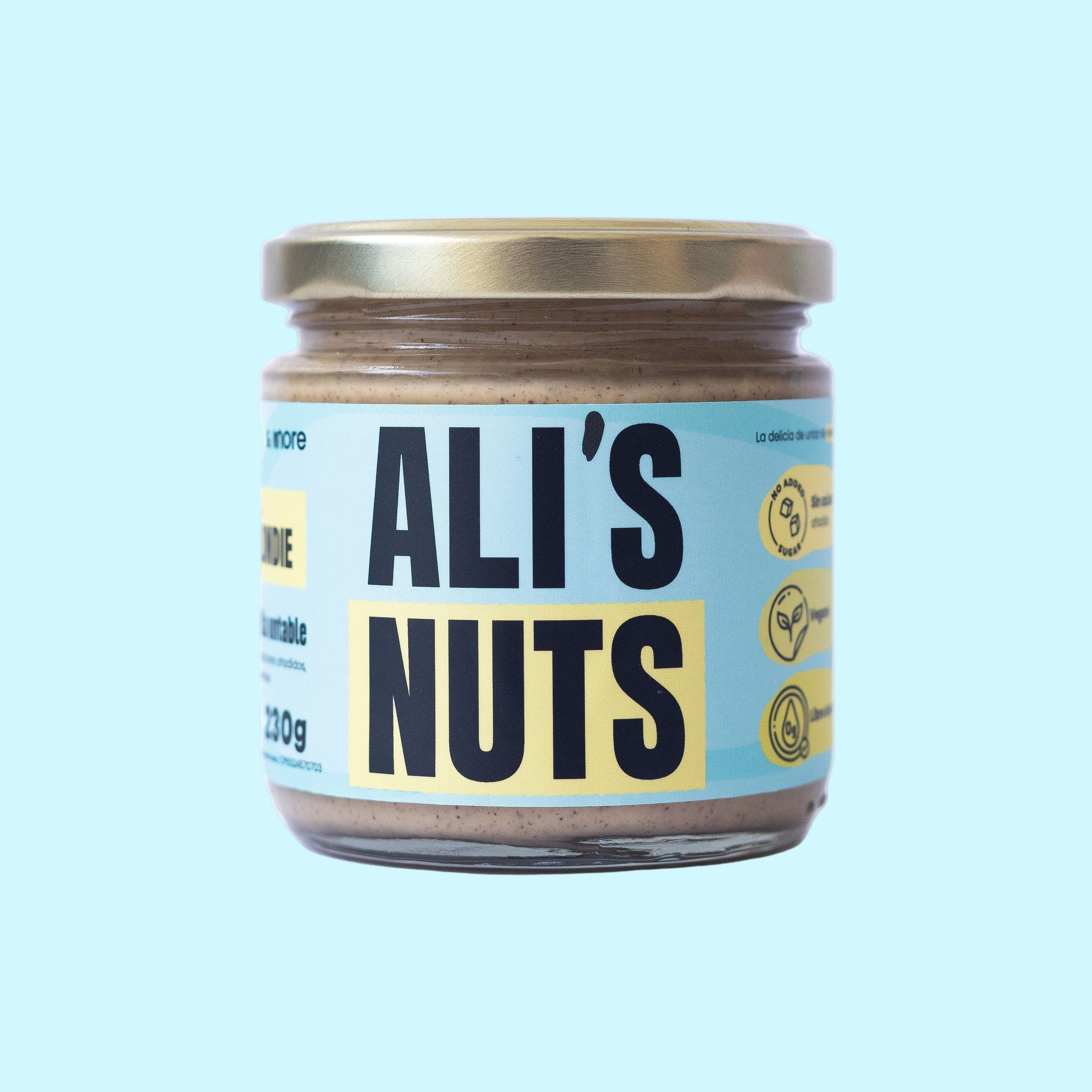 crema Blondie Ali’s Nuts con etiqueta azul pastel y tapa dorada sobre fondo celeste.”